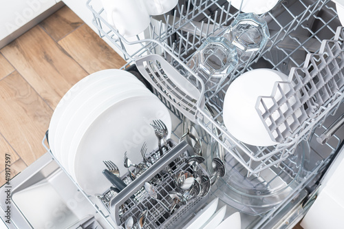 Open dishwasher with clean utensils in it