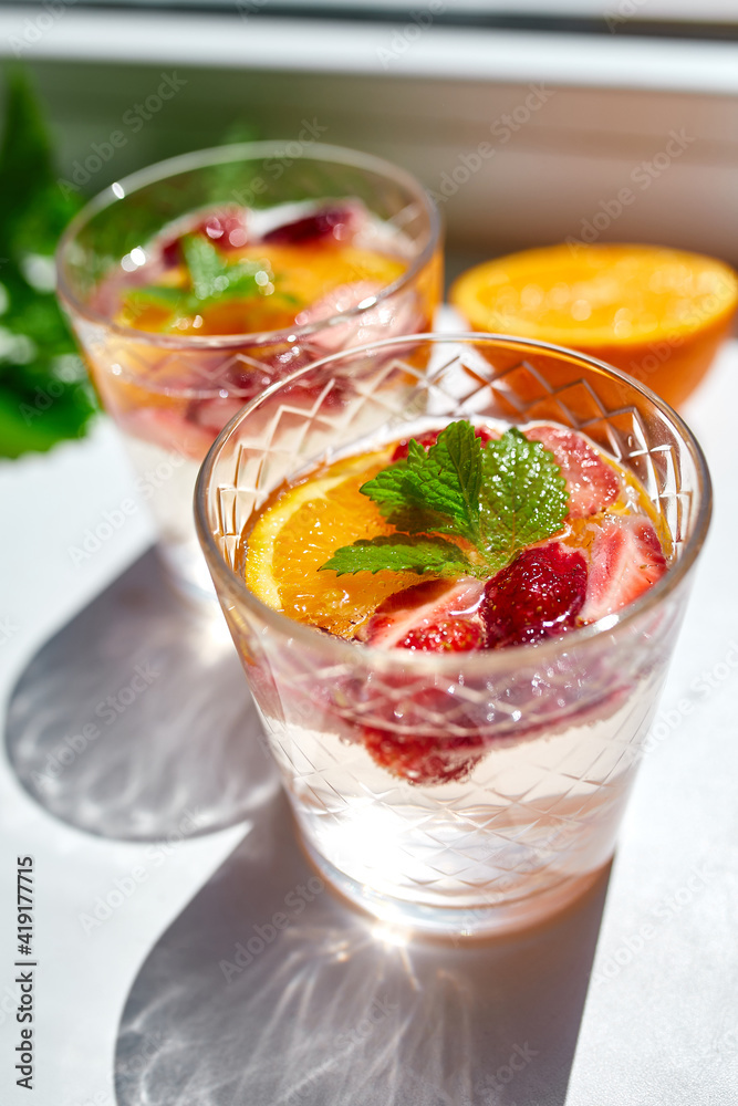 Summer cocktail with strawberry, orange and mint in glass Summer cocktail with strawberry, orange and mint in glass