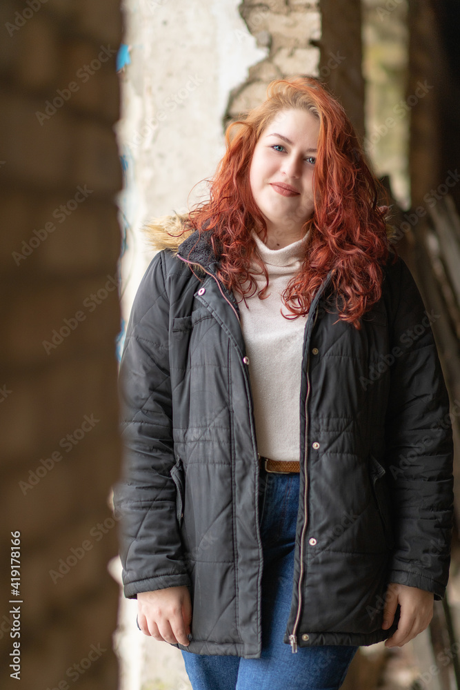 Portrait of a young red-haired girl in a dark jacket. Portrait of a young red-haired girl in a dark jacket.