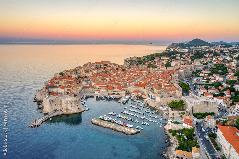 Aerial drone shot of Dubrovnik old town port with pink sky before sunrise in Dubronik summer morning