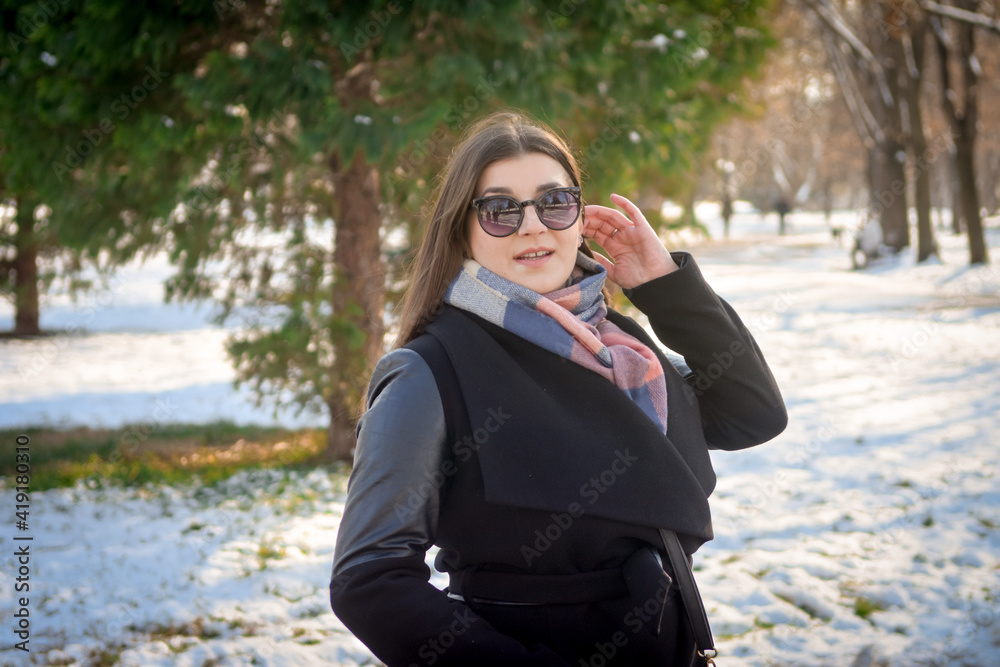 Portrait of a cheerful young girl posing in park on a sunny winters day. Portrait of a cheerful young girl posing in park on a sunny winters day.