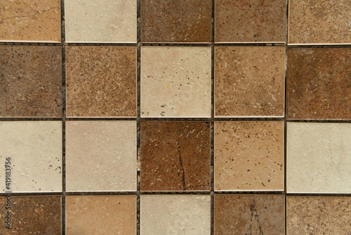 background of square ceramic tiles, with brown and beige stone imitation, top view