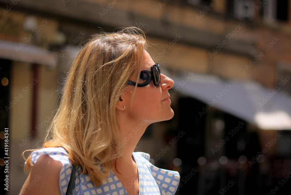 Portrait of a beautiful blonde woman in profile in black glasses on the background of the streets in Rome, Italy Portrait of a beautiful blonde woman in profile in black glasses on the background of the streets in Rome, Italy