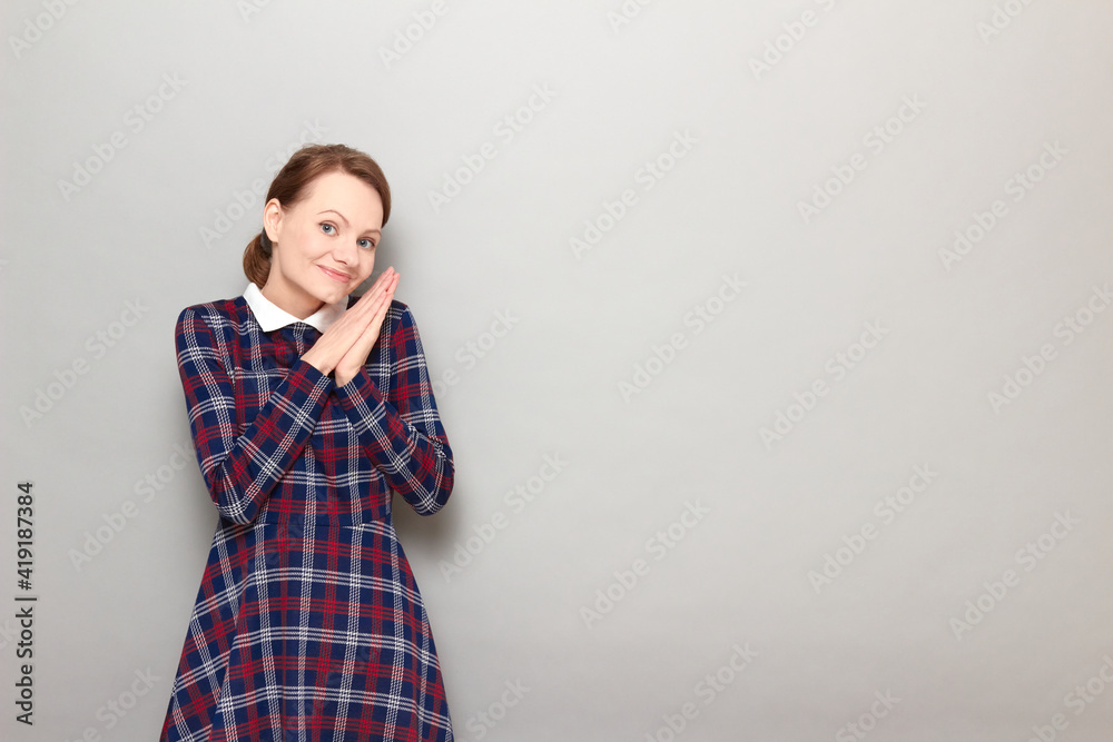 Portrait of happy girl holding hands together near face and smiling Portrait of happy girl holding hands together near face and smiling