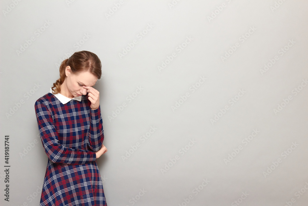Portrait of thoughtful tired girl touching bridge of nose with hand Portrait of thoughtful tired girl touching bridge of nose with hand