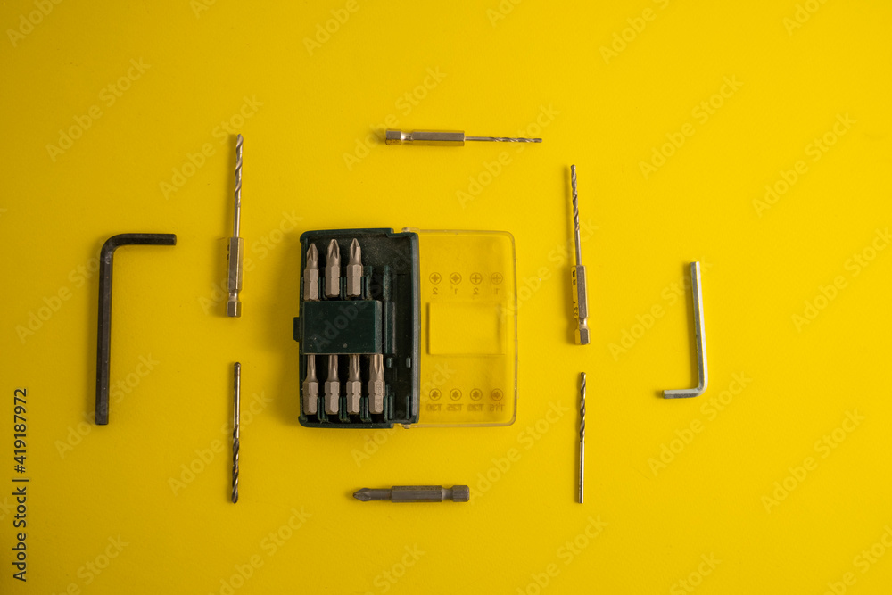 The drill bits on the yellow background with traces of dirt The drill bits on the yellow background with traces of dirt