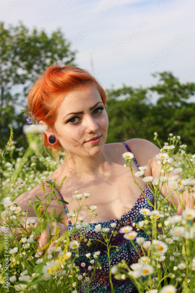 Beautiful young girl with red hair on a flower lawn enjoying nature. Harmony concept. Beautiful young girl with red hair on a flower lawn enjoying nature. Harmony concept.