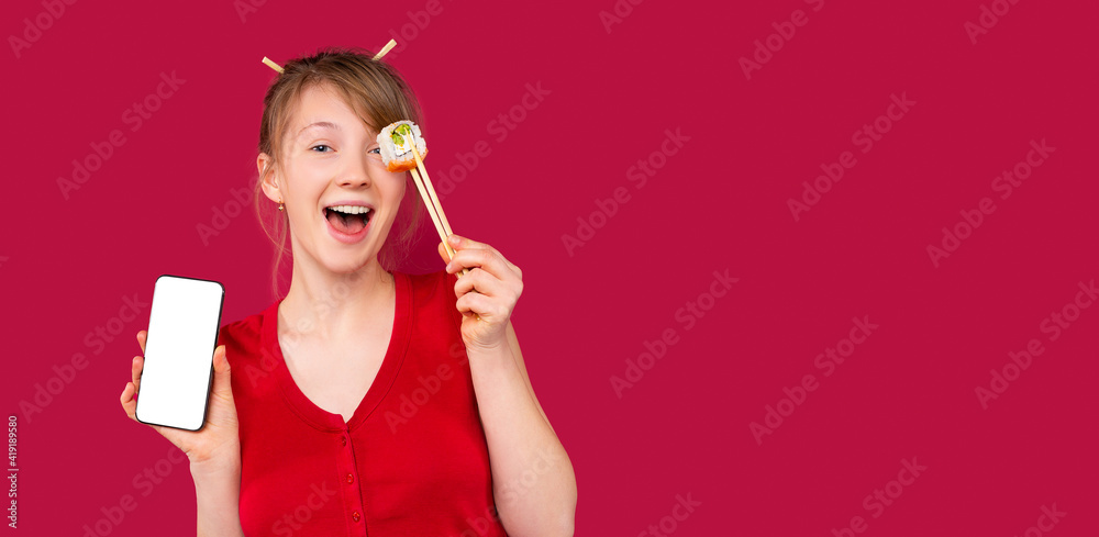 Banner, long format. Portrait of blonde girl holding sushi. Surprised girl opened her mouth wide. Red blouse on red background, monochrome, mock up mobile phone screen. Plenty space for advertisement Banner, long format. Portrait of blonde girl holding sushi. Surprised girl opened her mouth wide. Red blouse on red background, monochrome, mock up mobile phone screen. Plenty space for advertisement