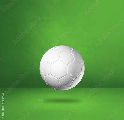 White soccer ball on a green studio background