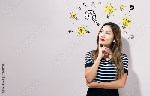 Question with light bulbs with young businesswoman in a thoughtful face photo
