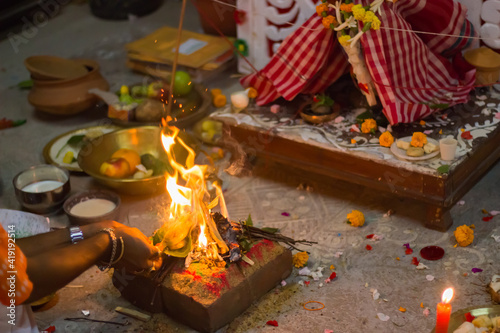 sacred fire burning during hindu religious rituals in local bengali culture. all the essential elements of puja are in the background. typical indian puja.