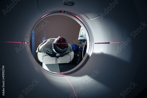 Senior man going through a Computerized Axial Tomography (CAT) Scan medical test/examination in a modern hospital (color toned image; shallow DOF) photo