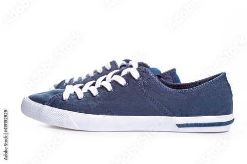 blue sneakers on white background with copy space. Youth shoes.