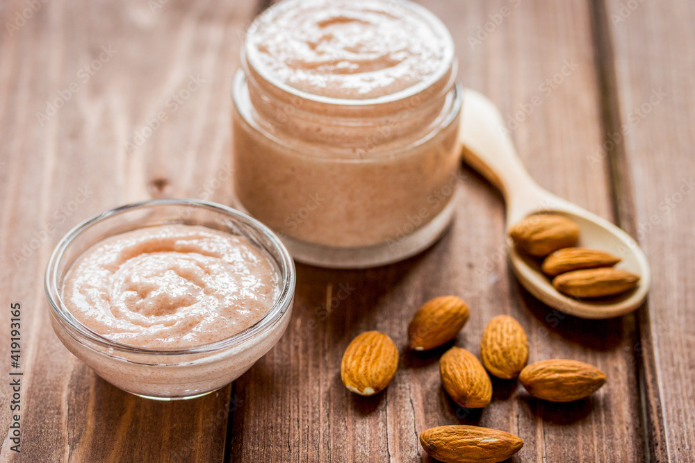 body scrub with almonds for body care on wooden table background body scrub with almonds for body care on wooden table background