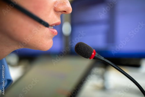 Call centre  employee communicating over phone using an external microphone for better sounf and ergonomics photo