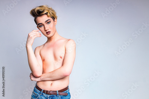 naked shirtless non binary portrait of asian man with luxurious blonde hair and gorgeous make-up in white wall studio background photo