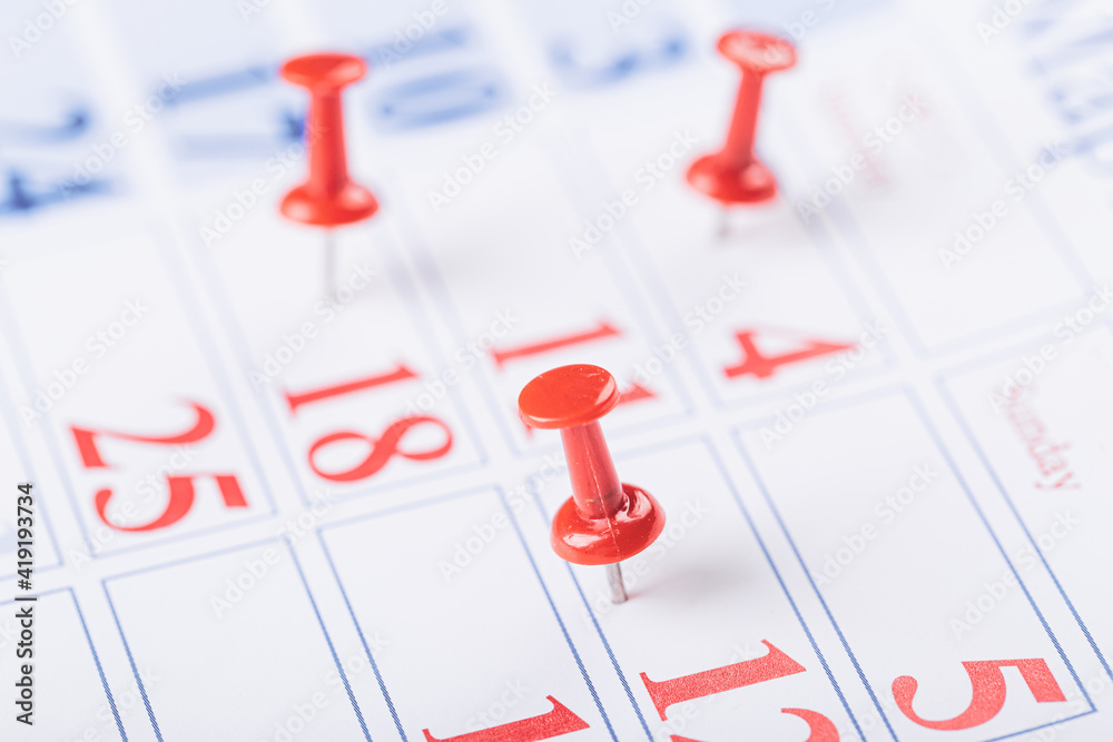 Calendar page for 2021, Concept image of a calendar with red push pins. Calendar page for 2021, Concept image of a calendar with red push pins.