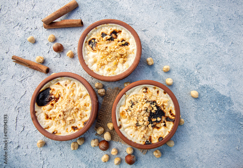 Baked rice pudding turkish milky dessert sutlac in earthenware casserole with hazelnuts photo