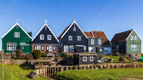 Historic Dutch fishing village with colorful wooden houses and church on the former island of Marken on the IJsselmeer in the Netherlands photo