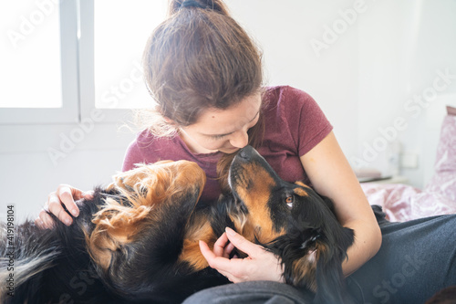 Caucasian girl lying in bed and hugging her dog. Palma de Mallorca, Spain