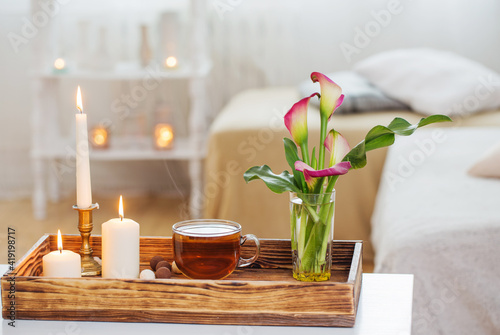 cup of tea and flowers on wooden tray indoor