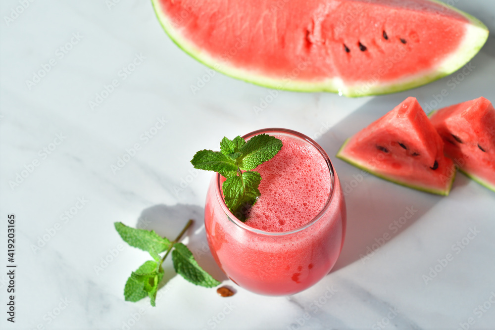 Fresh watermelon juice with mint and ice in the glass on white table.Sweet summer dessert, smoothie,cocktail healthy food concept, close up.Summertime. Copy spase. Selective focus Fresh watermelon juice with mint and ice in the glass on white table.Sweet summer dessert, smoothie,cocktail healthy food concept, close up.Summertime. Copy spase. Selective focus