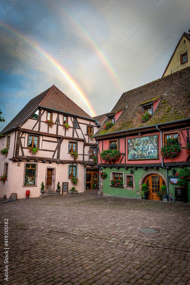 podwójna tęcza nad kolorowymi domkami w średniowiecznej wiosce Riquewihr, Alzacja, Francja - obrazy, fototapety, plakaty 