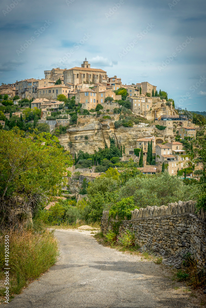 Fototapeta premium kamienna droga prowadząca do średniowiecznego miasteczka na wzgórzu.