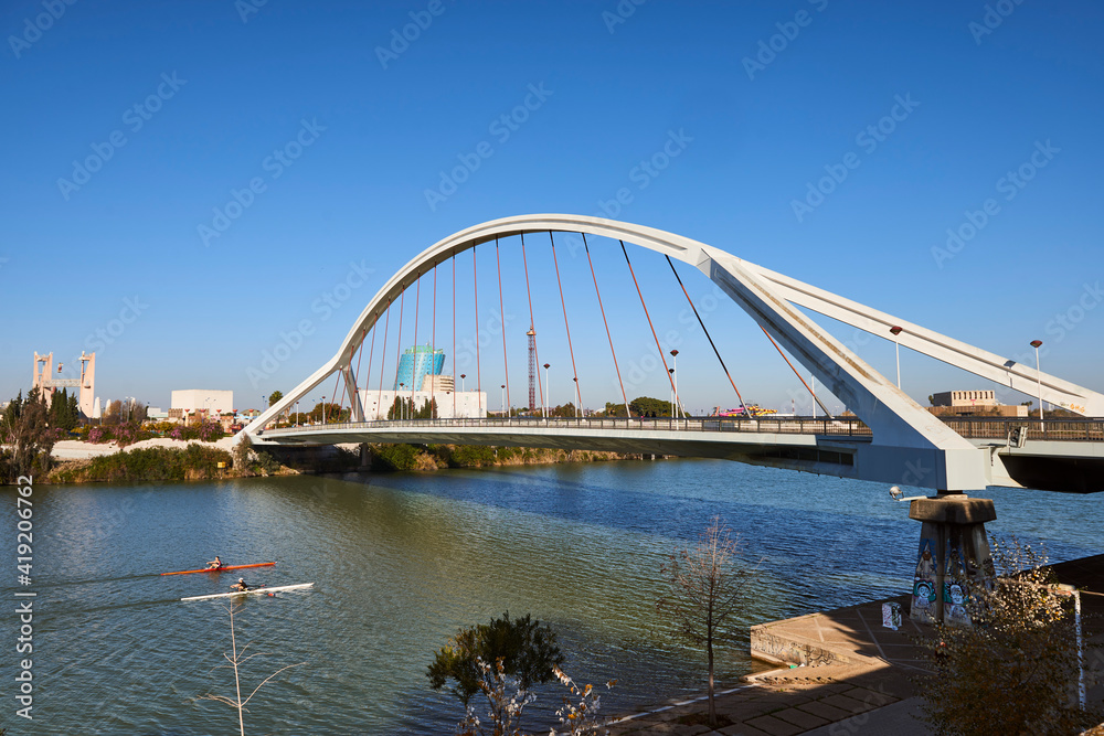 Rowboats in the Guadalquivir river and La Barqueta bridge, Seville, Spain Rowboats in the Guadalquivir river and La Barqueta bridge, Seville, Spain