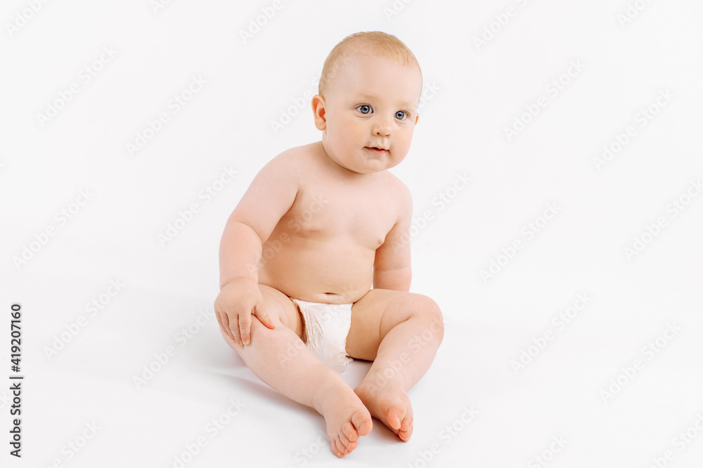 Happy baby in diaper sitting on isolated white background Happy baby in diaper sitting on isolated white background