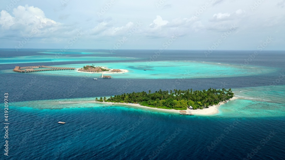 Bird's eye view of tropical islands in the ocean. View of the islands from a drone. Maldives, Thinadhoo (Vaavu Atoll), Dhigurah Bird's eye view of tropical islands in the ocean. View of the islands from a drone. Maldives, Thinadhoo (Vaavu Atoll), Dhigurah