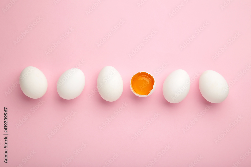 White eggs and egg yolk on the pink background. Easter concept White eggs and egg yolk on the pink background. Easter concept