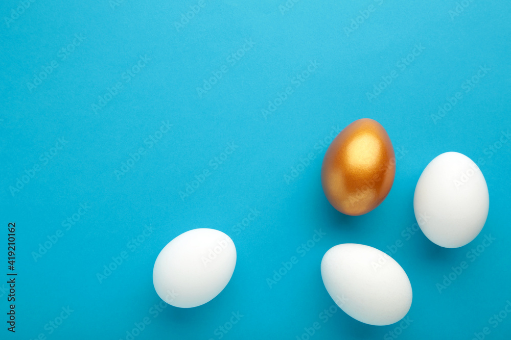 Gold egg with white on blue background Gold egg with white on blue background