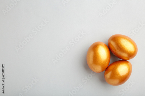 Gold Easter eggs on grey background. Spring concept.