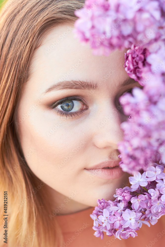 Young beautiful girl with a bouquet of lilacs. Walk in the fresh air. Freshness, spring and flowers concept.