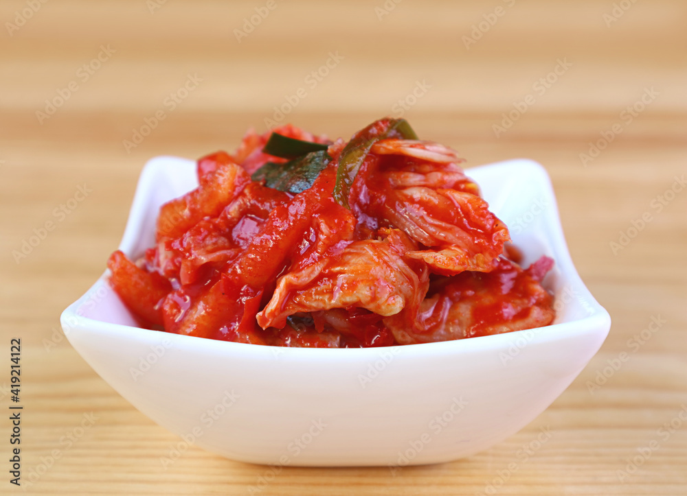 Closeup of Kimchi, an Iconic Korean Dish in White Bowl on Wooden Background Closeup of Kimchi, an Iconic Korean Dish in White Bowl on Wooden Background
