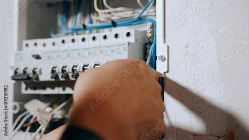 An electrician assembles an electrical panel in an apartment.