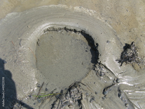 a sink hole with quicksand at a tidal beach at the coast along the sea