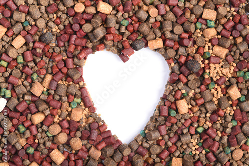fishing bait pellet background with various types and sizes of fish meal pellet and boilies shot from above macro, close up fathers day concept. heart shaped cut out with copy space