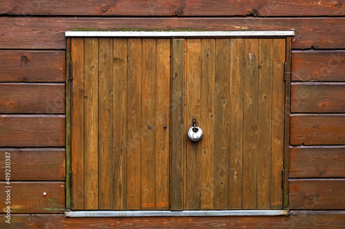 old broun wooden door or window on a house facade with lock