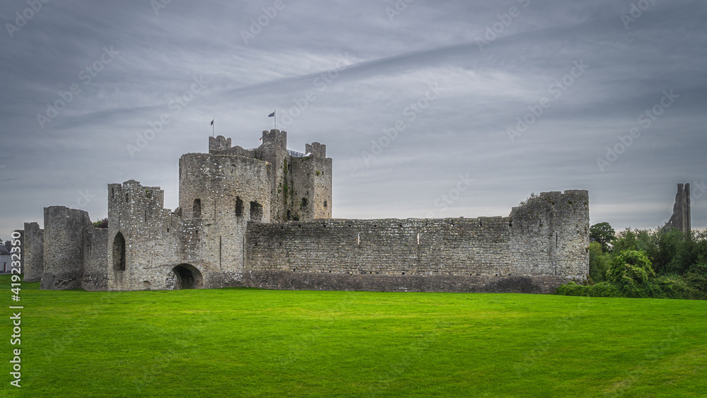 Panoramic view on old and ruined Trim Castle from 12th century, fortification walls with dark moody sky in Trim village, County Meath, Ireland