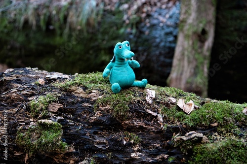 Wandern mit Kindern - Glücksbringer und Begleiter - Ein kleiner Drachen als Talismann  aus Plüsch in der Drachenschlucht auf einem bemoosten Stamm photo