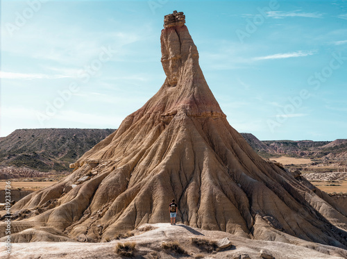 young boy with backpack and short jeans traveling in the desert landscape of Bardenas Reales, Navarra