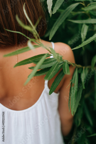 half-naked female back close-up and green summer leaves © Natalia