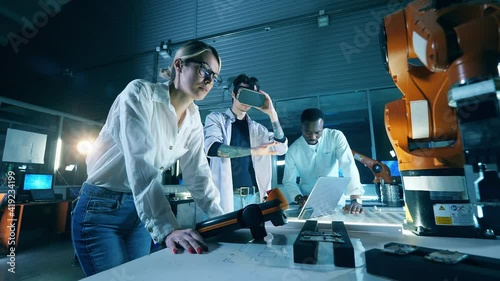 Researchers are using VR-device for a robotics experimentProfessional engineers working with innovative equipment, teamwork concept.