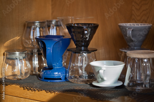 several glass and ceramic pour over devices closeup in coffee shop
