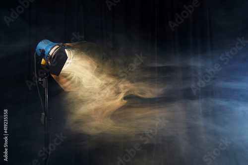 Photo studio lighting equipment on black background with smoke