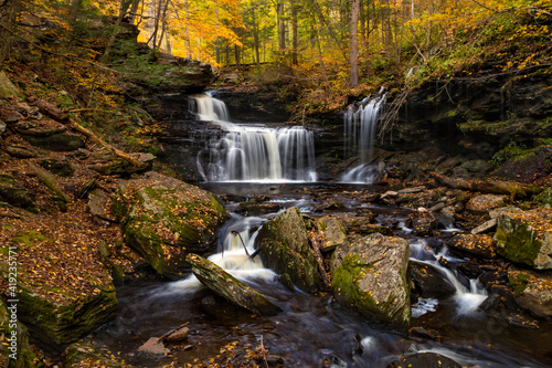  colorful autumn foliage with calming cascading waterfall in Pennsylvania.