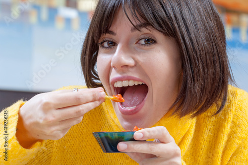 Primo piano di una bella ragazza allegra che mangia cibo messicano photo