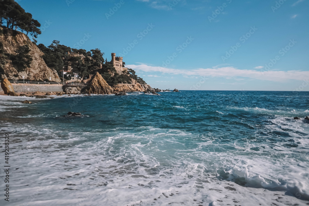 Paisaje de mar con olas, rocas y espuma en la costa.